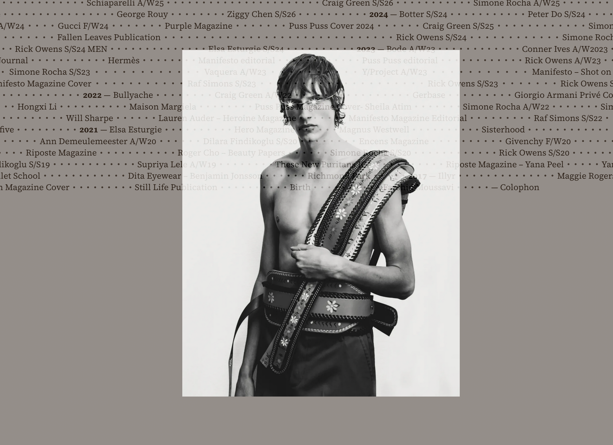Browser screenshot showing website with long lines of dark-gray serif type, overlaying black and white fashion photograph.
